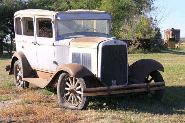 Old rusty car in a field