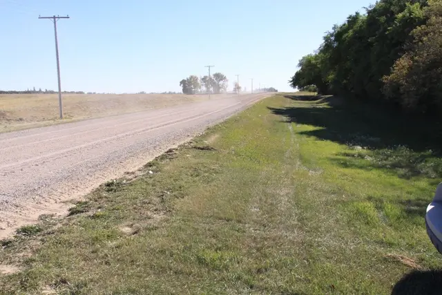 Gravel road and grassy ditch on the prairie